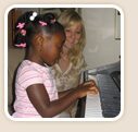 Young student playing piano with her teacher